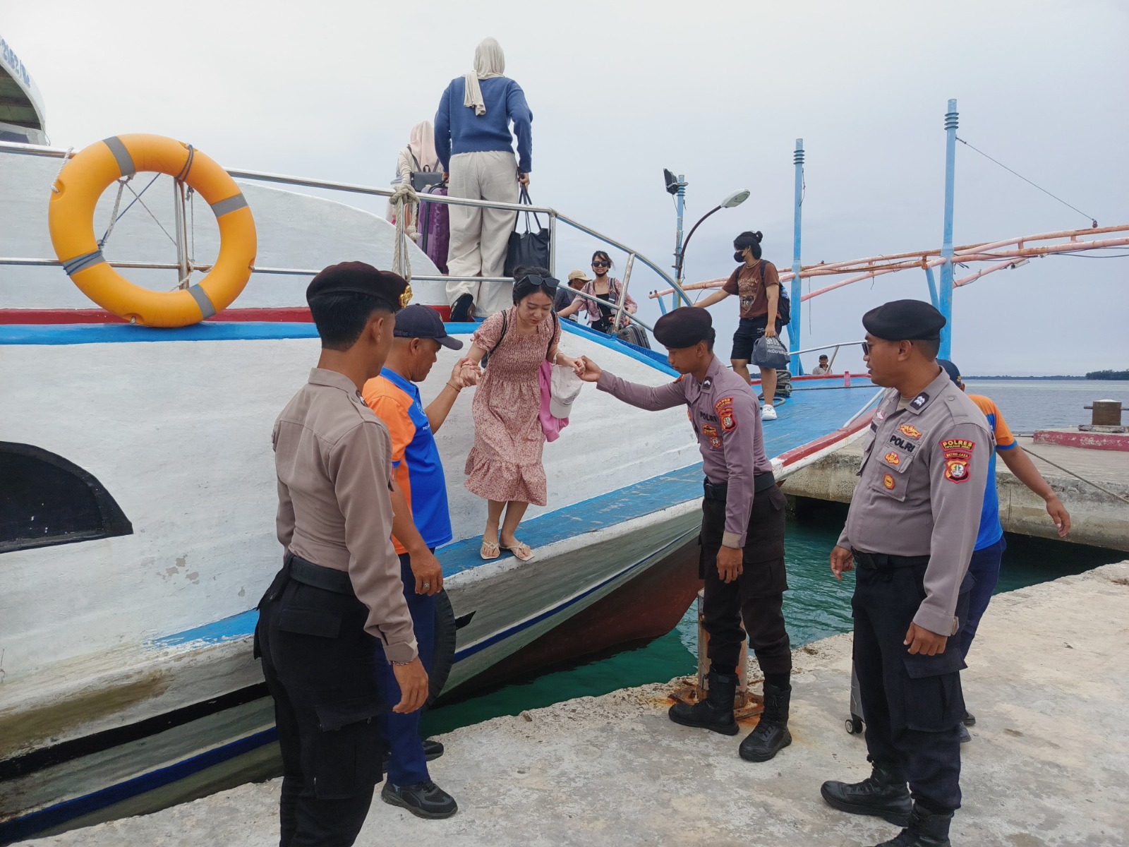Kanit Sabhara Polsek Kepulauan Seribu Utara Bantu Penumpang di Dermaga Pulau Harapan